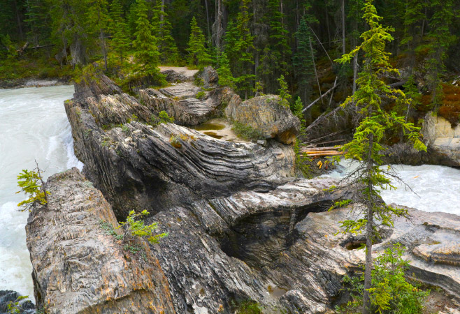 Natural Bridge is an impressive natural rock formation that spans the flow of the Kicking Horse River west of Field.